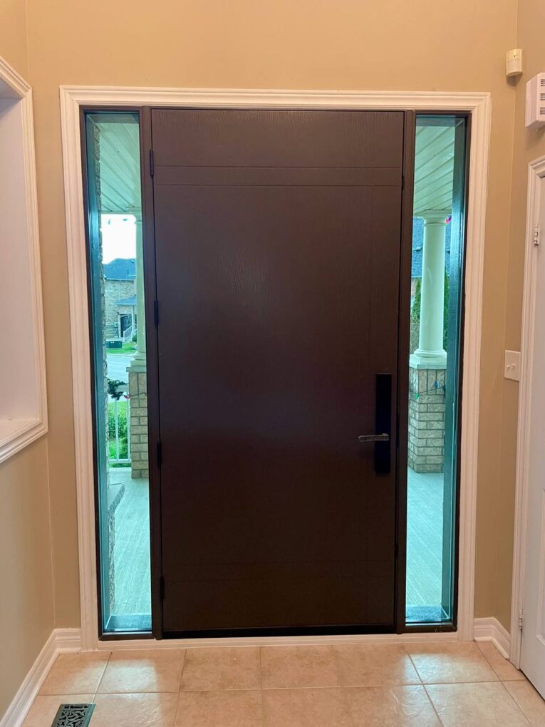 Interior view of the new flush fiberglass entry door with narrow sidelites bringing light into the hallway.