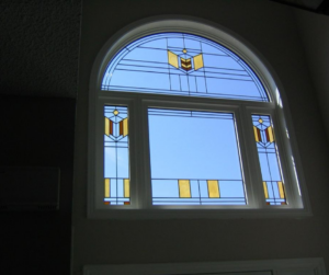 Interior view of arched window with decorative stained glass panels