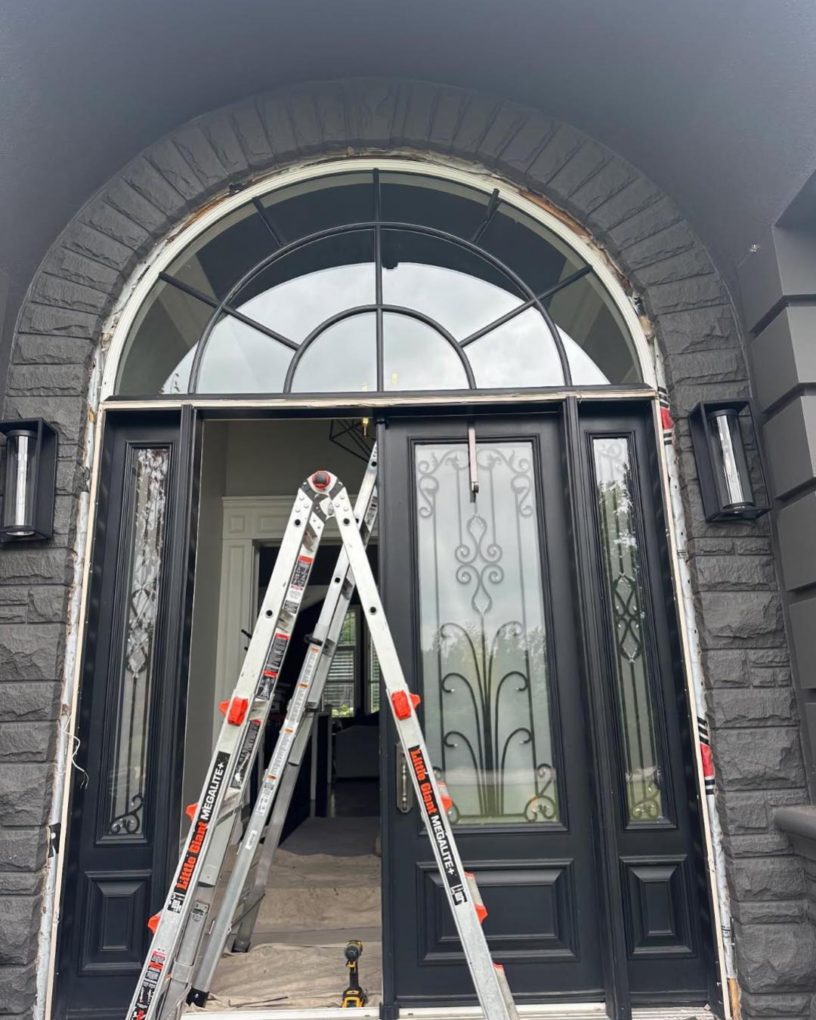 Before photo of traditional double entry doors with decorative glass and arched window above