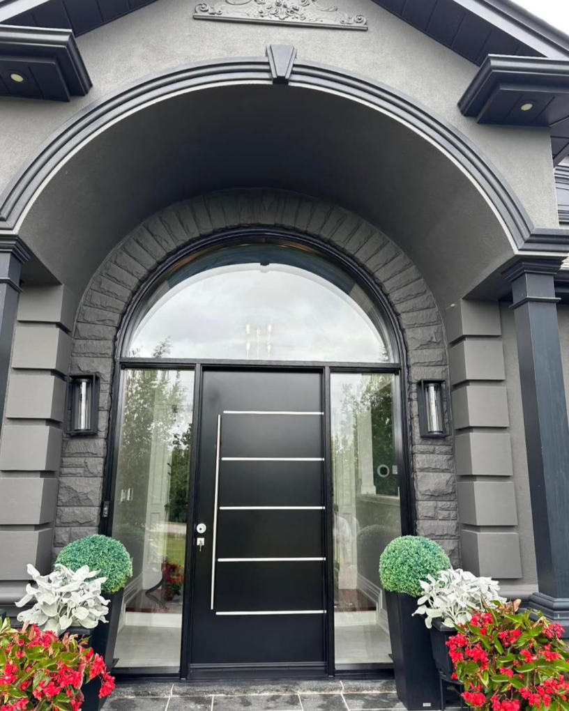 Exterior view of a modern matte black front door with arched transom and full-height sidelites on a GTA home