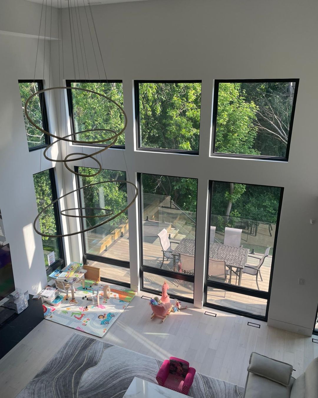 Expansive wall of energy-efficient picture windows in a high-ceilinged contemporary home, showcasing natural light.