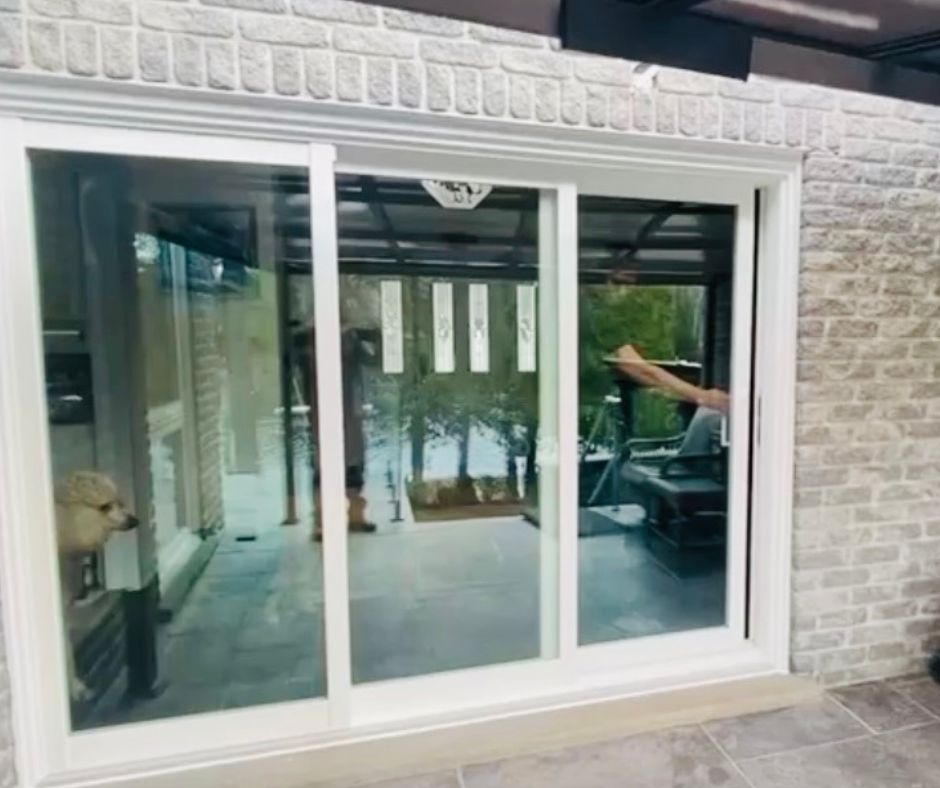Close-up of the new sliding patio door frame replacing the old garden doors in the same brick opening.