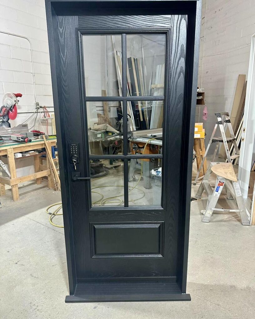 Arched fiberglass entry door in Oakville with a black finish and large grid glass insert.