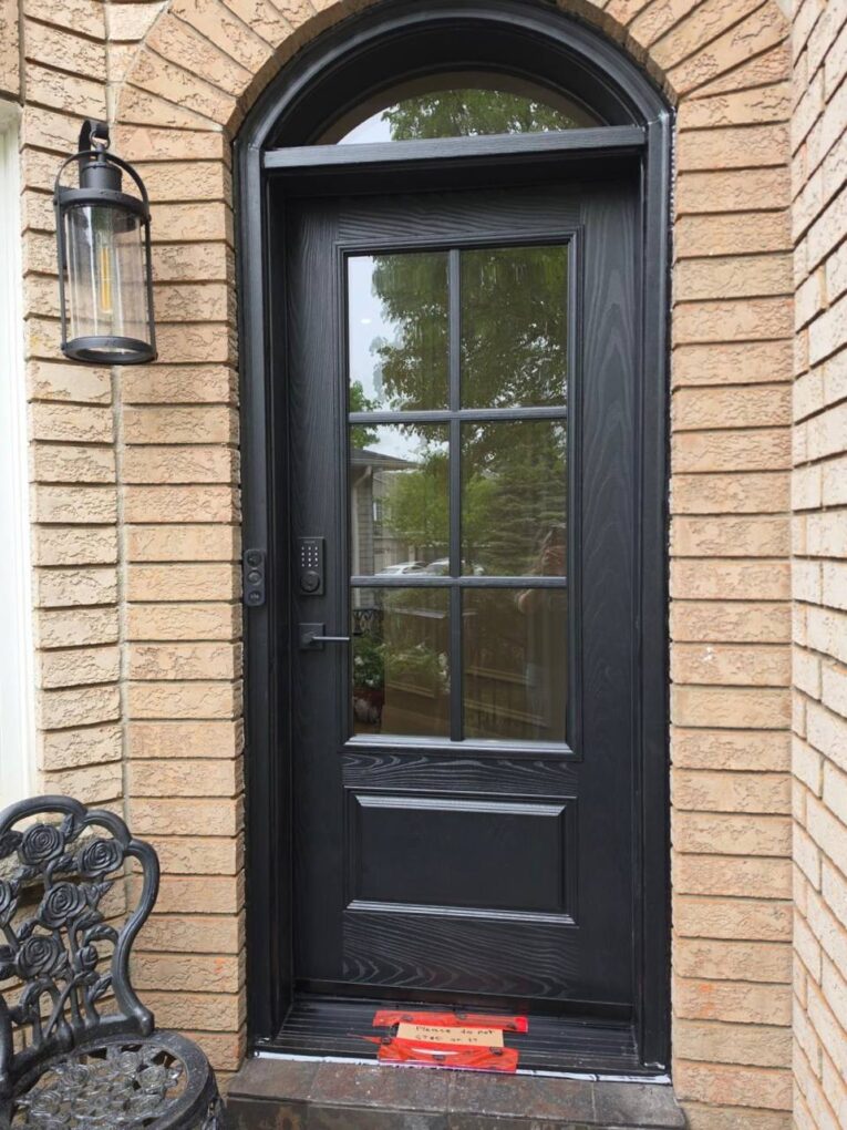 Before and after view of an arched front door replacement on a brick home in Oakville.