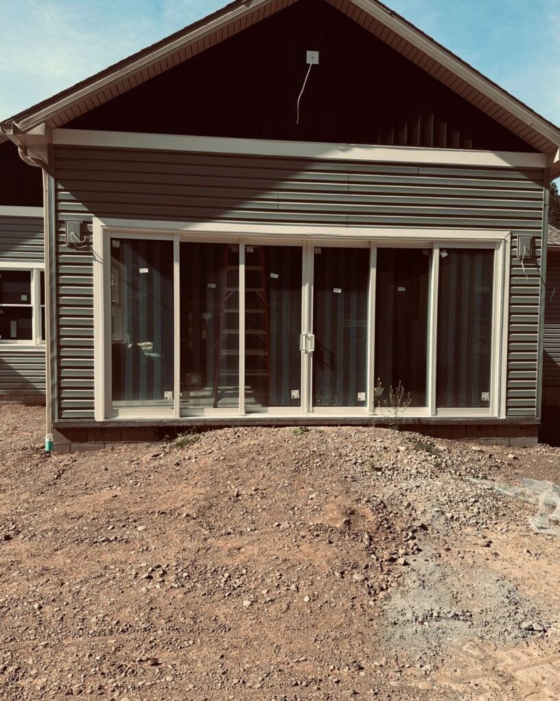 Bright interior space with a custom 6 panel patio door and wide glass span across the back wall