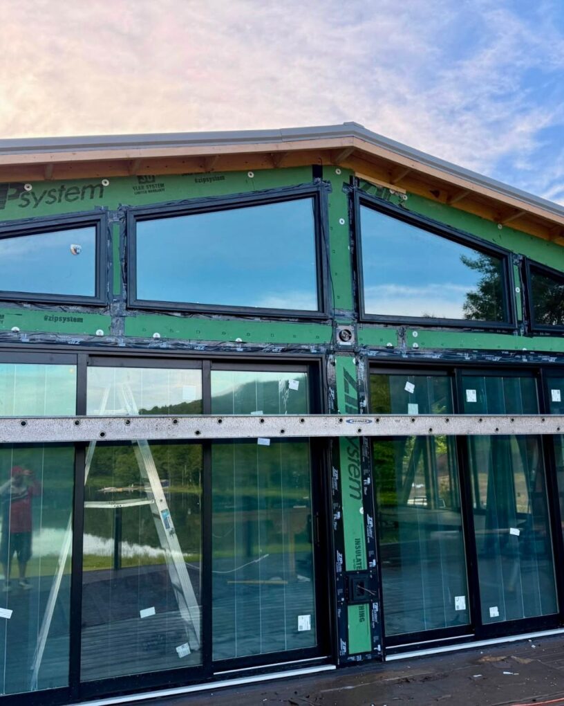 Custom shaped windows and large sliding door systems installed across the front façade.