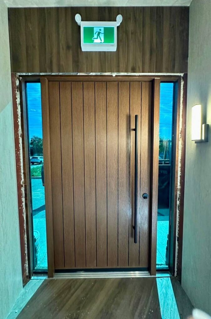 Custom woodgrain fiberglass restaurant entrance with sidelights