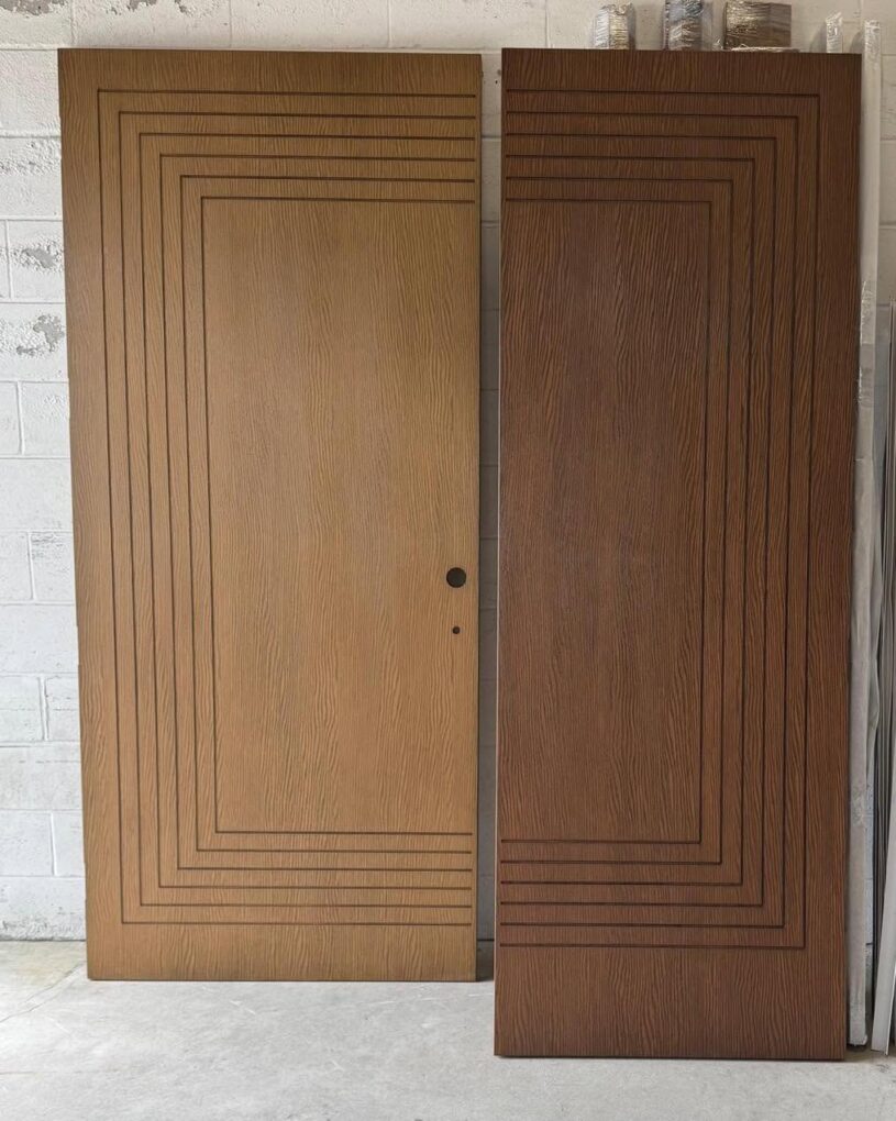 Two fiberglass wood look entry doors with matching geometric designs and different finishes